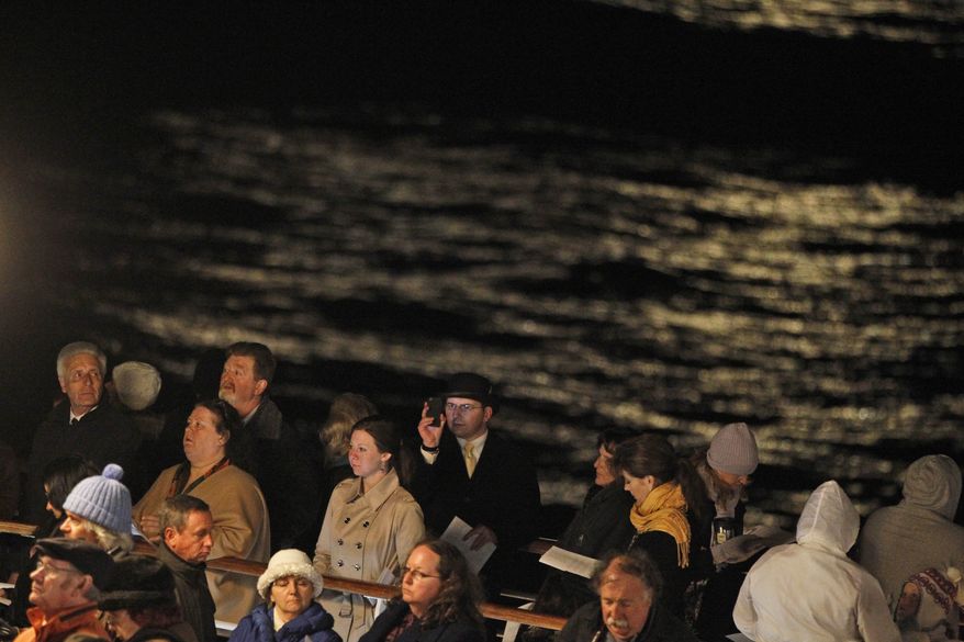 Passengers aboard the MS Balmoral participate in a memorial service early on Sunday, April 15, 2012, to mark the centenary of the Titanic disaster. The passengers and crew said prayers at the spot in the North Atlantic Ocean where the Titanic sank, with the loss of more than 1,500 lives. (AP Photo/Lefteris Pitarakis)