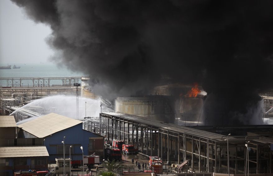 Firefighters use water canons against a blaze in the storage facilities of an oil company in Suez, Egypt, on Sunday, April 15, 2012. One person died and dozens were injured in the fire, which raged for nearly 20 hours, the local police chief said. (AP Photo/Khalil Hamra)