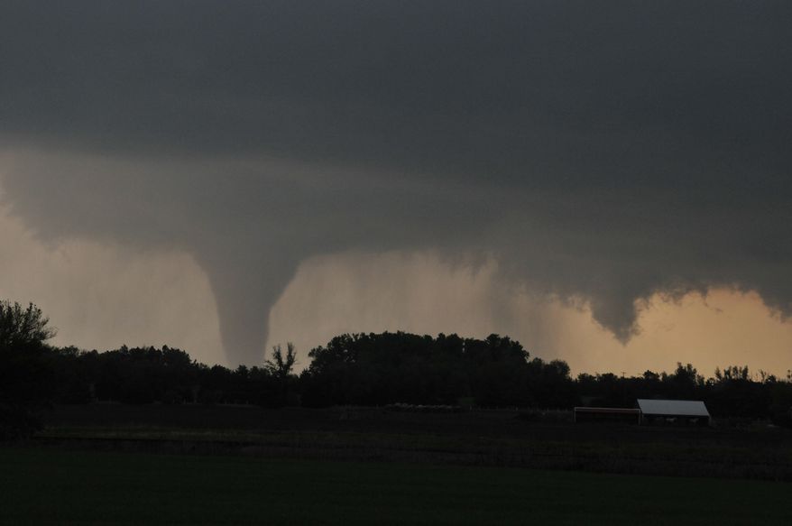 A tornado moves on the ground north of Solomon, Kan., on Saturday evening, April 14, 2012. Interstate 70 is in the foreground. (AP Photo/The Hutchinson News, Sandra J. Milburn)
