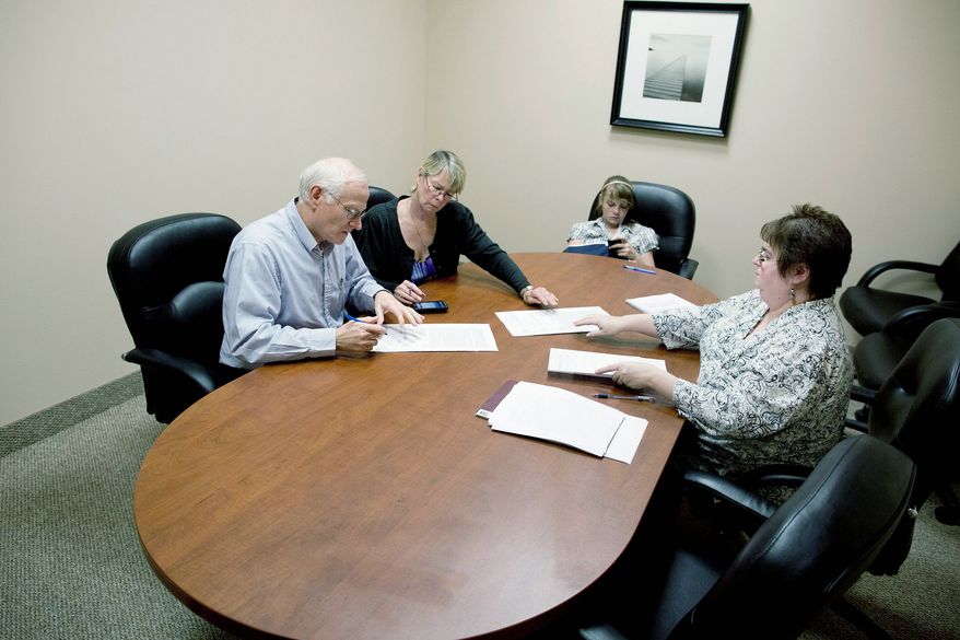 Bill and Kelly Noorish (above) bring along 12-year-old Nyomie as they sign papers with escrow assistant Deb Arebalo. The Noorishes will be moving with their 32-year-old son and his wife into a Las Vegas home like the one shown by Joy Broddle (below). (Associated Press)