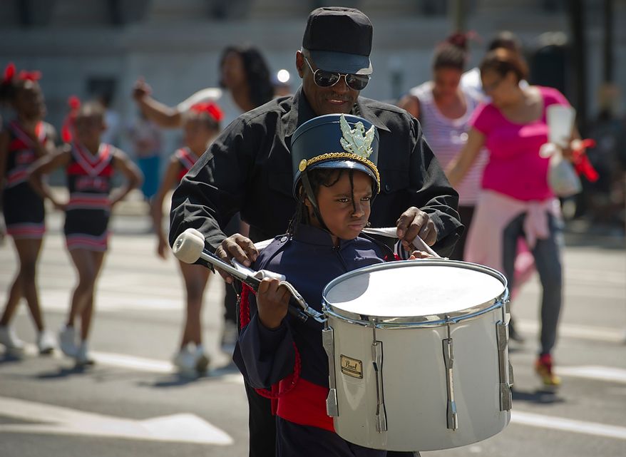 A young drummer in the JC Nalle Elementary School band gets a little help adjusting his instrument as they make they way along Pennsylvania Avenue NW during the District of Columbia Emancipation Day 2012 parade in Washington, D.C., Monday, April 16, 2012., celebrating the150th anniversary of the District of Columbia Emancipation Act. 150 ears ago, on April 16, 1862, President Abraham Lincoln signed a bill ending slavery in the District of Columbia. Passage of this law came 8 1/2 months before President Lincoln signed his Emancipation Proclamation. (Rod Lamkey Jr/The Washington Times)