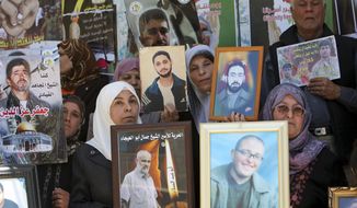 Demonstrators holding photographs of Palestinians jailed in Israel rally in the West Bank city of Jenin on Tuesday, April 17, 2012, to mark the annual &quot;Prisoners&#39; Day.&quot; (AP Photo/Mohammed Ballas)