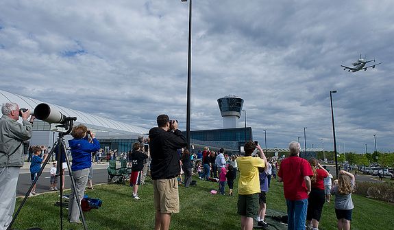 People photograph the space shuttle Discovery as it flies piggyback on a 747 past the Smithsonian Air and Space Museum Udvar-Hazy Center in Chantilly, Va., on Tuesday, April 17, 2012. The shuttle left the Kennedy Space Center Tuesday morning and flew around Washington, D.C. before finally landing at Washington Dulles International Airport. Discovery will now be towed over to the Udvar-Hazy center, where it will take the place of the Enterprise in a welcoming ceremony on Thursday. (Barbara L. Salisbury/The Washington Times)