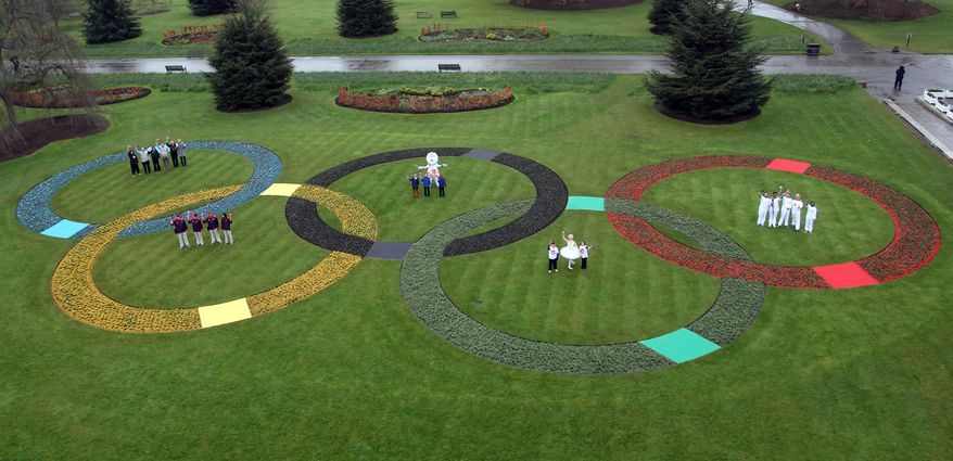 Giant Olympic rings made up of 25,000 flowers are seen April 18, 2012, at Kew Royal Botanic Gardens in London with torchbearers, games makers, London 2012 festival participants and parents of TeamGB athletes, marking 100 days before the start of the London 2012 Olympic Games. The opening ceremony will take place on July 27, 2012. (Associated Press)