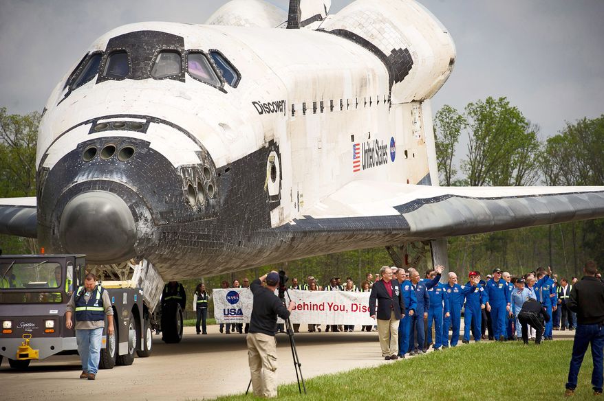 Discovery is towed into place behind the stage to be used as a backdrop during the celebration of its arrival at the Steven F. Udvar-Hazy Center in Chantilly on Thursday. (Rod Lamkey Jr./The Washington Times)