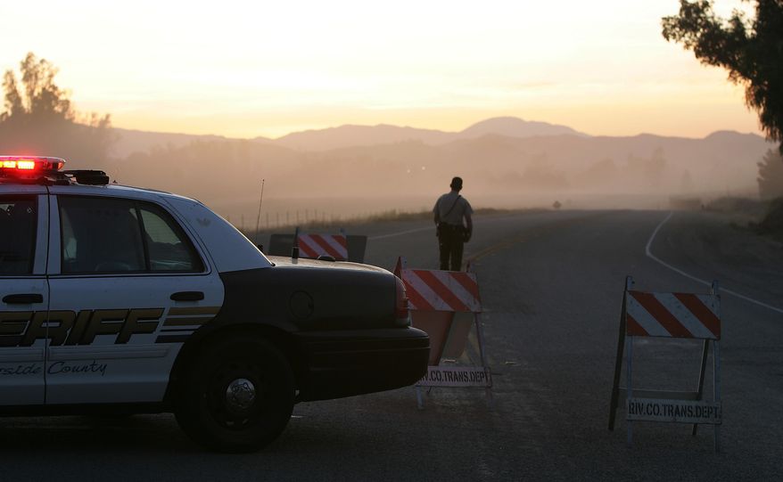 A deputy stands April 17, 2012, at a roadblock where a body was found near Lake Skinner near Winchester, Calif. Detectives searching for Brittany Dawn Killgore, who had been missing for four days, found the body after it was spotted by a maintenance worker leaving the area after clearing brush. (Associated Press/The Press-Enterprise)