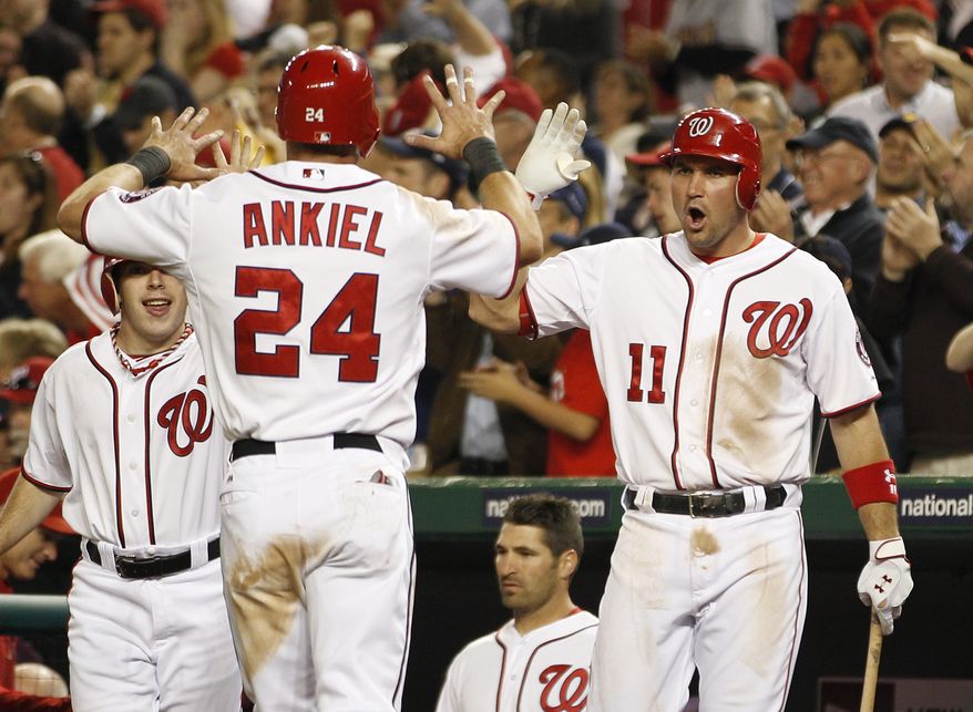 Washington Nationals Ryan Zimmerman congratulates teammate Rick Ankiel who scored a run during the eighth inning of against the Miami Marlins on Friday, April 20, 2012, in Washington. The Nationals defeated the Marlins 2-0. (AP Photo/Evan Vucci)