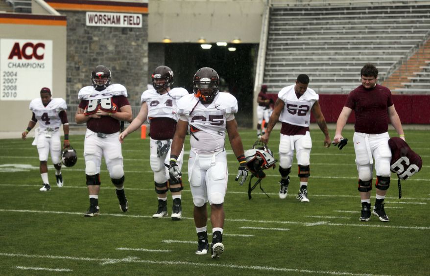 Virginia Tech's Martin Scales (25) and teammates walk across the field after their spring football game was canceled due to weather in Blacksburg, Va., on Saturday, April 21, 2012. (AP Photo/The Roanoke Times, Matt Gentry)