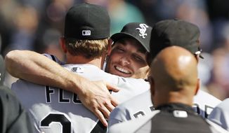 Chicago White Sox starting pitcher Philip Humber, center, is mobbed by teammates after pitching a perfect baseball game against the Seattle Mariners, Saturday, April 21, 2012, in Seattle. The White Sox won 4-0. (AP Photo/Elaine Thompson)
