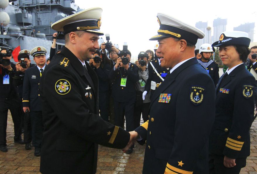 Rear Adm. Du Xiping (front right), deputy commander of China's Beihai Fleet, shakes hands with Capt. 1st Rank Sergei Yuriyevich Zhuga of Russia's Pacific Fleet during a welcome ceremony at a naval base in Qingdao, in east China's Shandong Province, on Saturday, April 21, 2012. Joint Chinese-Russian maritime drills are scheduled from April 22 to 27 on the Yellow Sea, Xinhua News Agency said. (AP Photo/Xinhua, Zha Chunming)