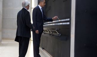 President Obama, accompanied by Elie Wiesel, a Nobel Peace Prize laureate and Holocaust survivor, lights a candle in the Hall of Remembrance as they tour the U.S. Holocaust Memorial Museum in Washington on Monday, April 23, 2012. (AP Photo/Carolyn Kaster)
