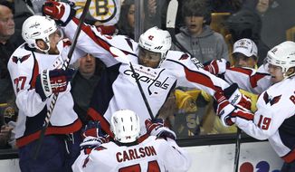 Washington Capitals right wing Joel Ward, center, is congratulated by teammates after his game-winning goal against the Boston Bruins during overtime of Game 7 of the first-round series in Boston on Wednesday, April 25, 2012. The Capitals won 2-1. (AP Photo/Charles Krupa)