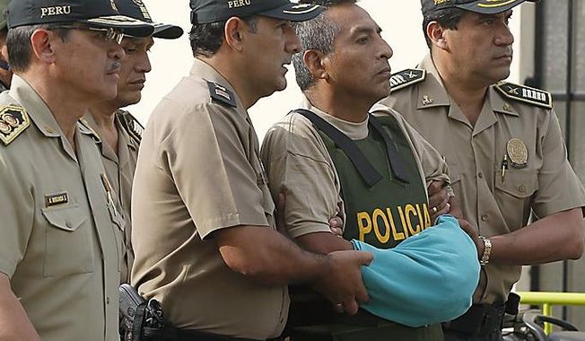 ** FILE ** A top leader of the once-powerful Shining Path rebel group, Comrade Artemio, whose given name is Florindo &quot;Juan&quot; Flores, center, is escorted by police officers outside a police hospital in Lima, Peru, Wednesday Feb. 22, 2012. Flores was captured by Peruvian troops on Sunday, Feb. 12, in the remote coca-growing Upper Huallaga Valley of central Peru. (AP Photo/Martin Mejia)
