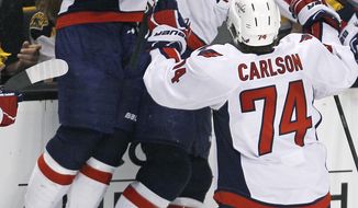 Washington Capitals right wing Joel Ward, center, is congratulated by teammates after scoring the game-winner in overtime against the Boston Bruins in Game 7 of their first-round series. (AP Photo/Charles Krupa)
