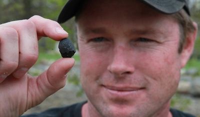 Robert Ward displays on April 25, 2012, one of two pieces of a meteorite he found at a park in Lotus, Calif. The meteor was probably about the size of a minivan when it entered the Earth's atmosphere three days earlier with a loud boom at about 8 a.m. (Associated Press)