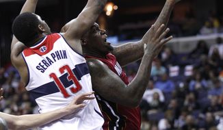 Miami Heat center Eddy Curry, right, drives to the basket against Washington Wizards forward Kevin Seraphin during the first half of an NBA basketball game on Thursday, April 26, 2012, in Washington. (AP Photo/Evan Vucci)