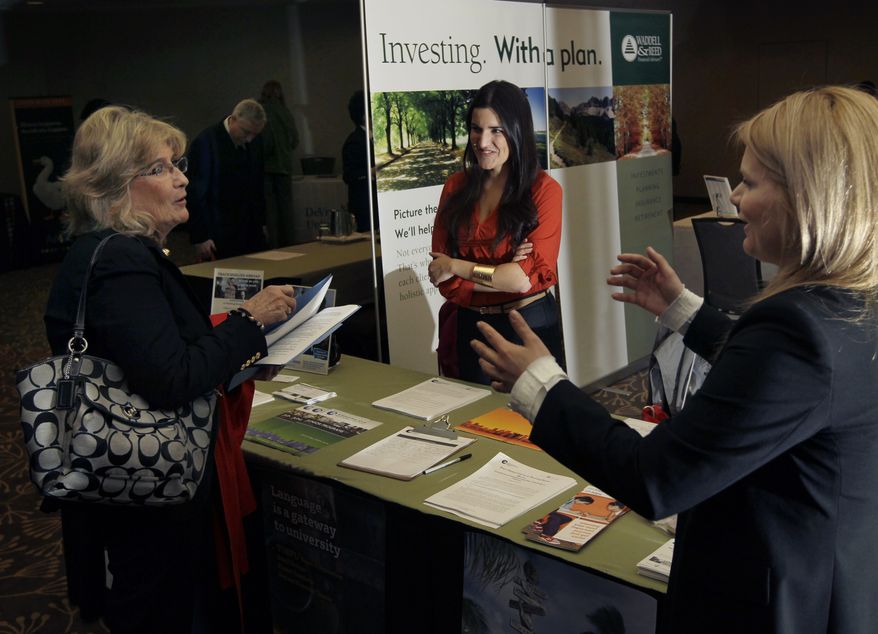 Iulia Petelea (right) and Carolina Baso (center) of International House speak with a potential applicant during a job fair in Boston on Monday, April 2, 2012. (AP Photo/Elise Amendola)