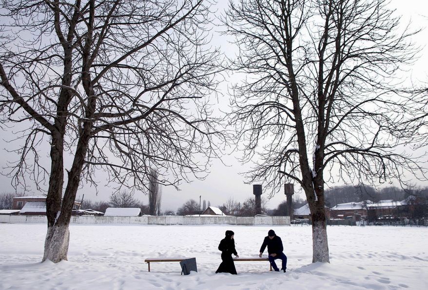 A man and a woman on a date in the village of Serzhen-Yurt in Chechnya sit on opposite ends of a bench. Couples on dates must meet in public and sit a distance from each other. All physical contact is forbidden before marriage. Chechen President Ramzan Kadyrov supports honor killings for women with "loose morals." (Diana Markosian/Special to The Washington Times)