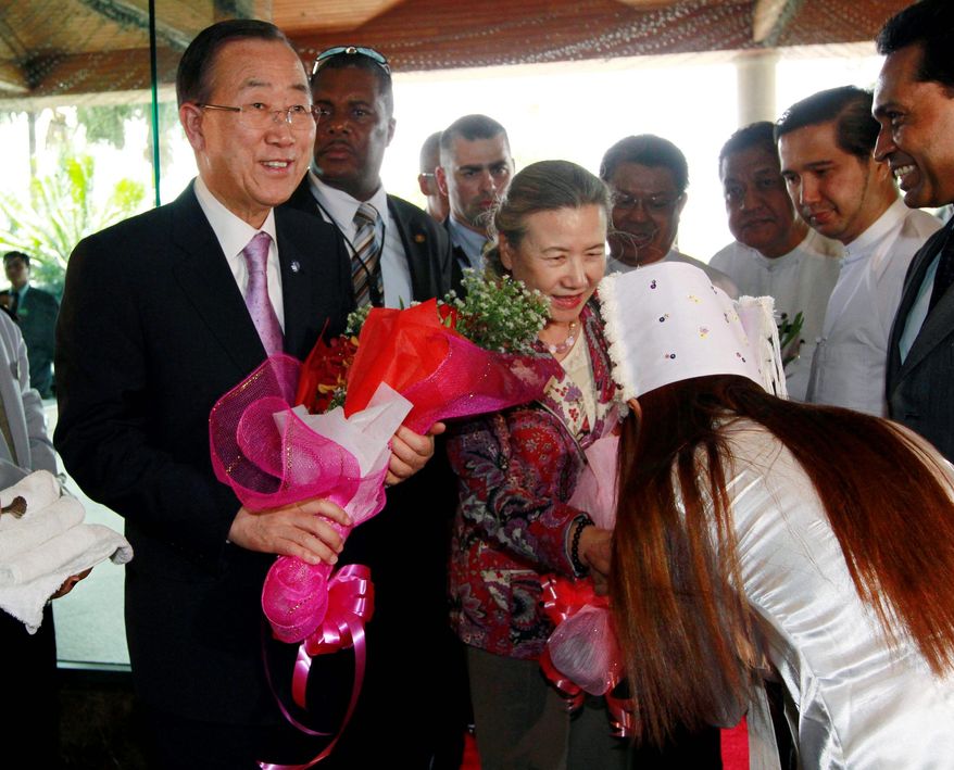U.N. Secretary-General Ban Ki-moon (left) and his wife, Yoo Soon-taek (center), receive flowers upon their arrival in Yangon, Myanmar, on Sunday. Mr. Ban will see how the world body can help promote the country's steps toward democratic reform. He will meet President Thein Sein during the three-day visit. (Associated Press)