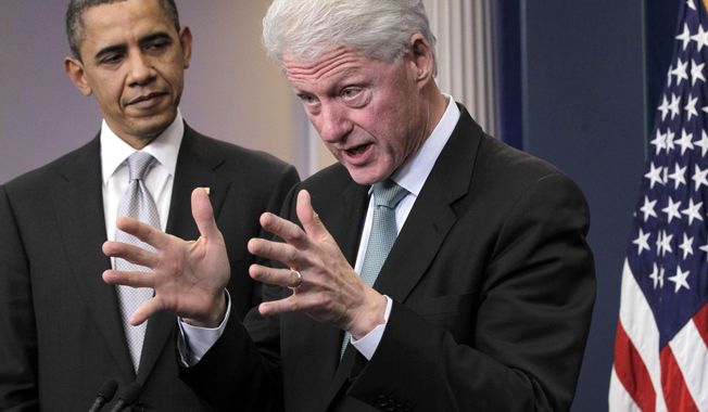 **FILE** President Obama listens to former President Bill Clinton speak Dec. 10, 2010, in the White House briefing room in Washington. (Associated Press)