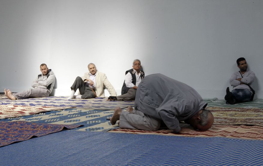 **FILE** French Muslims attend a mass prayer Sept.16, 2011, at a prayer hall in a unused former fire station in Paris. (Associated Press)