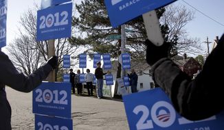 Supporters of President Obama hold signs April 30, 2012, near a campaign stop for Republican presidential candidate and former Massachusetts Gov. Mitt Romney in Portsmouth, N.H. (Associated Press)