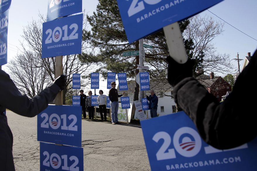 Supporters of President Obama hold signs April 30, 2012, near a campaign stop for Republican presidential candidate and former Massachusetts Gov. Mitt Romney in Portsmouth, N.H. (Associated Press)