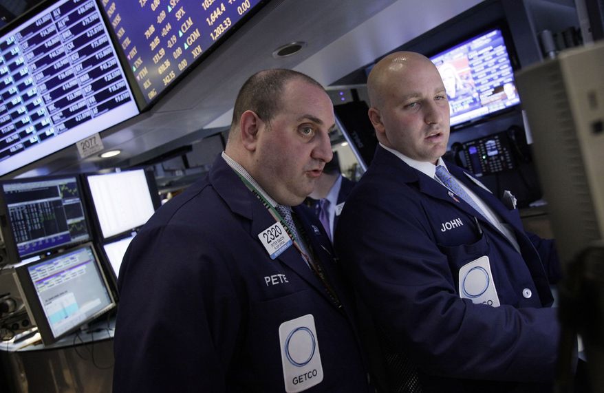 ** FILE ** Specialists Peter Giacchi (left) and John Parisi confer on the floor of the New York Stock Exchange on Wednesday, April 25, 2012. (AP Photo/Richard Drew)