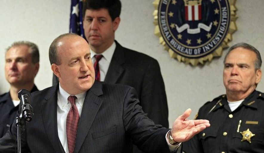 FBI Special Agent in Charge Stephen Anthony points to a map of an attempted bridge bombing at the bureau's office in Cleveland Tuesday, May 1, 2012. Five men, pictured on the wall behind the map, have been arrested for conspiring to blow up the high level bridge over the Cuyahoga River valley. (AP Photo/Mark Duncan)