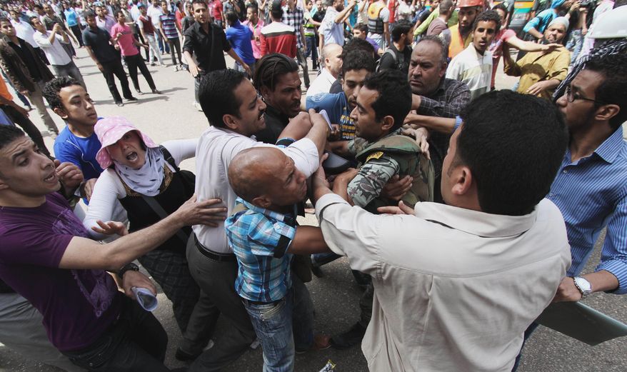 Protesters clash with an Egyptian soldier outside the Defense Ministry in Cairo on Wednesday, May 2, 2012. (AP Photo)