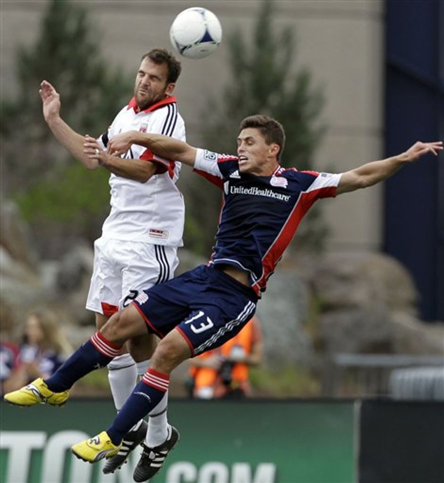 D.C. United's Daniel Woolard (21) competes for the ball against New England Revolution's Ryan Guy during the first half in Foxborough, Mass., on Saturday, April 14, 2012. (AP Photo/Elise Amendola)