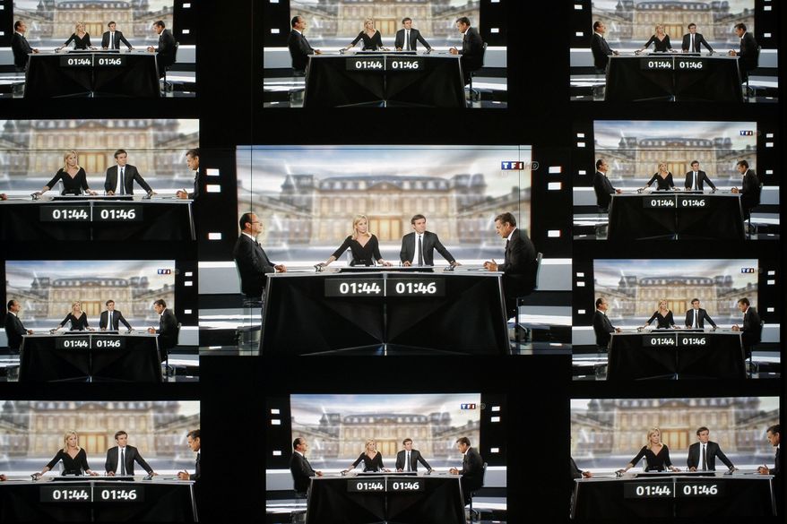 A wall screen shows the televised debate between Francois Hollande, Socialist Party candidate for the presidential election and Nicolas Sarkozy, current president and conservative rival for re-election, at the TF1 television studio in Boulogne-Billancourt, outside Paris on May 2, 2012. (Associated Press)