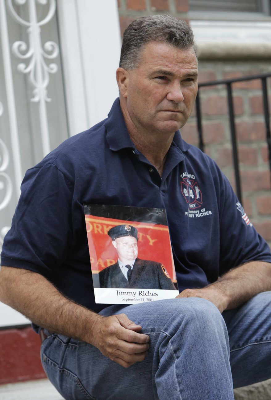 Retired firefighter Jim Riches poses for a picture with a photography of his son near his home in New York, Thursday, May 3, 2012. Riches, whose son was killed during the 2001 terrorist attacks on the World Trade center, will be among those to watch the arraignment of Khalid Sheikh Mohammed. (AP Photo/Seth Wenig)