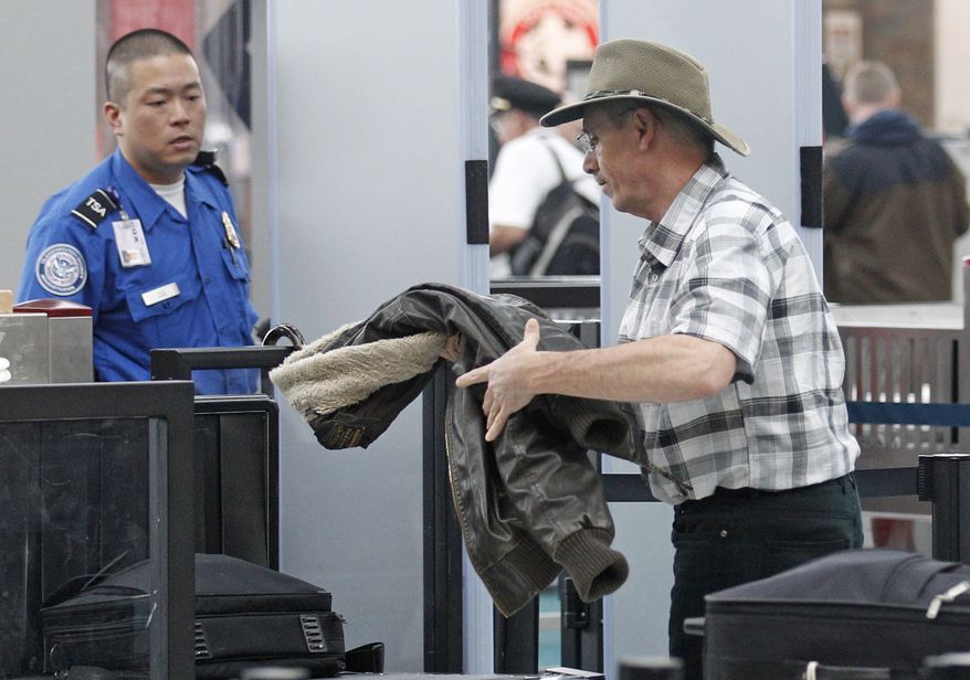 A traveler passes April 30, 2012, through a security check point at Portland International Airport, in Portland, Ore. (Associated Press)