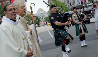 While Monsignor Salvatore Criscuolo, left, pastor at St. Patrick's in the City, listens, Cardinal Donald Wuerl, Archbishop of Washington, sings "Amazing Grace" as members of the Washington, D.C. Regional Police Pipe Band play outside of St. Patrick's in the City following the conclusion of the annual Blue Mass honoring law enforcement and public safety officials Tuesday, May 8, 2012 in Washington, D.C. (Barbara L. Salisbury/The Washington Times)