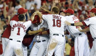 Washington Nationals&#39; Wilson Ramos, center, is mobbed by teammates after hitting the game-winning RBI in the 11th inning to defeat the Philadelphia Phillies 4-3 at Nationals Park on Friday, May 4, 2012, in Washington. (AP Photo/Richard Lipski)
