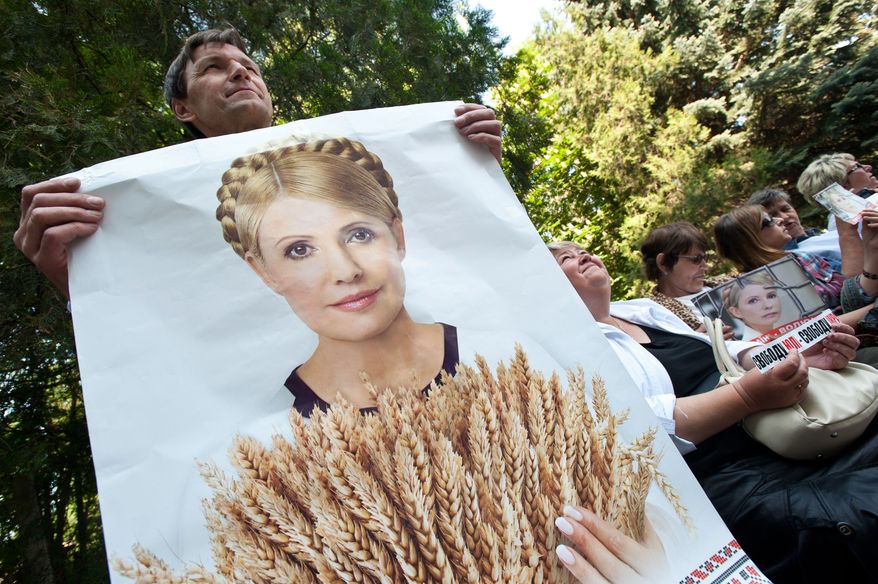 A supporter of former Ukrainian Prime Minister Yulia Tymoshenko holds a poster of her in front of a state-run hospital in Kharkiv, Ukraine, on Wednesday, May 9, 2012. (AP Photo/dapd, Alexey Furman)
