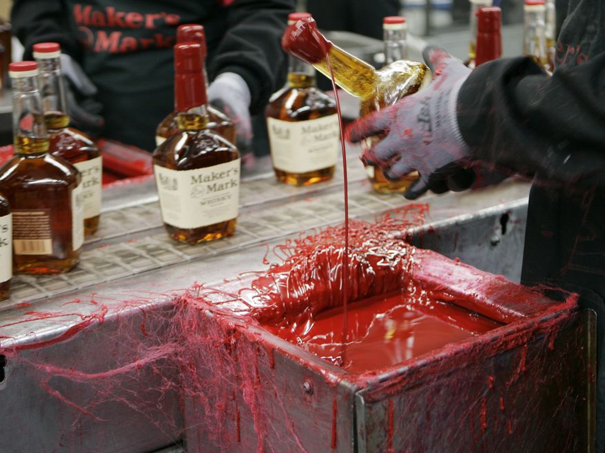 A bottle of Maker's Mark bourbon is dipped in red wax at the company's distillery in Loretto, Ky., in April 2009. (AP Photo/Ed Reinke)