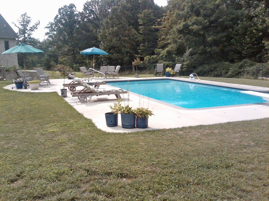 Besides the in-ground pool, the backyard features multilevel decks, a three-season gazebo and a pool house.