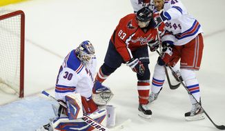 New York Rangers goalie Henrik Lundqvist and Stu Bickel battle for the puck against Washington Capitals center Jay Beagle during Game 4 of their second-round playoff series Saturday, May 5, 2012, in Washington. (AP Photo/Nick Wass)