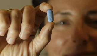 Dr. Lisa Sterman holds up a Truvada pill at her office in San Francisco on May 10, 2012. The pill, already used to treat people with HIV, also helps prevent the virus from infecting healthy people. (Associated Press)