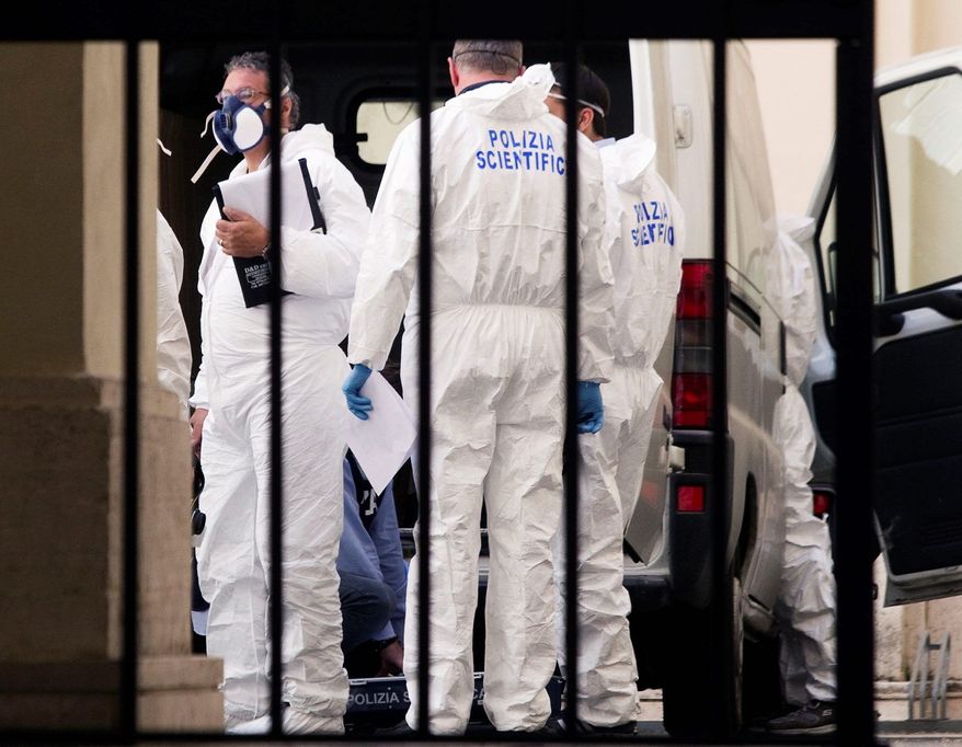 Forensic police officers work in the courtyard of Sant' Apollinare basilica in Rome on Monday. Police swarmed the crypt at the basilica to exhume the body of reputed mobster Enrico De Pedis as part of an investigation into the 1983 disappearance of the teenage daughter of a Vatican employee, Emanuela Orlandi. (Associated Press)