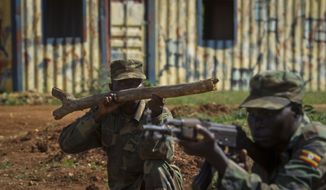 **FILE** Soldiers from the Uganda People&#39;s Defense Force (UPDF), one holding a piece of wood representing a weapon, engage April 30, 2012, in urban operations training in a mock urban setting nicknamed &quot;Little Mogadishu&quot; at the Singo training facility in Kakola, Uganda. (Associated Press)