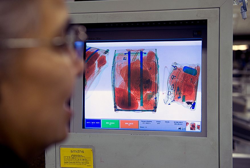 The high-tech X-ray machine used by Customs and Border Inspection agents in the Agriculture Inspection Area color-codes organic (orange), plastic (green) and metal (blue) items for easier identification. Here an officer looks at bags on the screen on Wednesday, Feb. 8, 2012 at Washington Dulles International Airport. (Barbara L. Salisbury/The Washington Times)