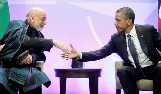 President Obama shakes hands with Afghan President Hamid Karzai during their meeting at the NATO summit in Chicago on Sunday. Mr. Karzai thanked Americans for the help their &quot;taxpayers&#x27; money&quot; has done in Afghanistan. (Associated Press)