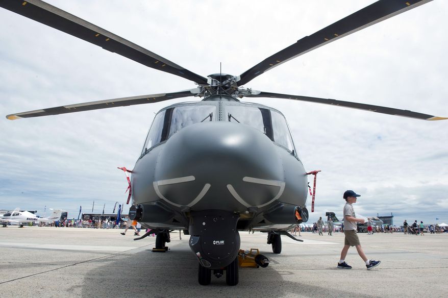Matthew Saccone, 7, of Hampstead, Md., strides from an AF139M helicopter at the Joint Service Open House & Air Show on Sunday. Visitors could get up close to aircraft on the ground and watch flying manuevers. (Barbara L. Salisbury/The Washington Times)