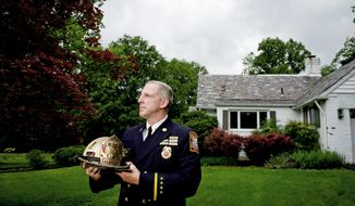 Battalion Fire Chief Kevin B. Sloan stands in front of his parents&#39; home in Kensington. He said the shift change that followed his transfer is making it difficult for him to help care for his elderly parents. He plans to file a complaint challenging the transfer ordered by Fire Chief Kenneth Ellerbe. (Rod Lamkey Jr./The Washington Times)