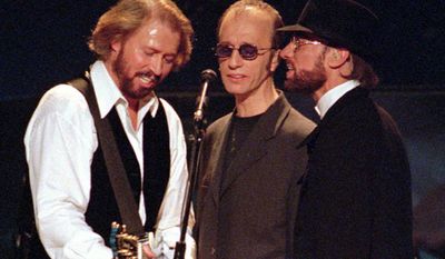 The Bee Gees, from left, Maurice, Robin and Barry Gibb sing together in their first U.S. performance in five years, at the MGM Grand in Las Vegas, Friday, Nov. 14, 1997. (Associated Press)