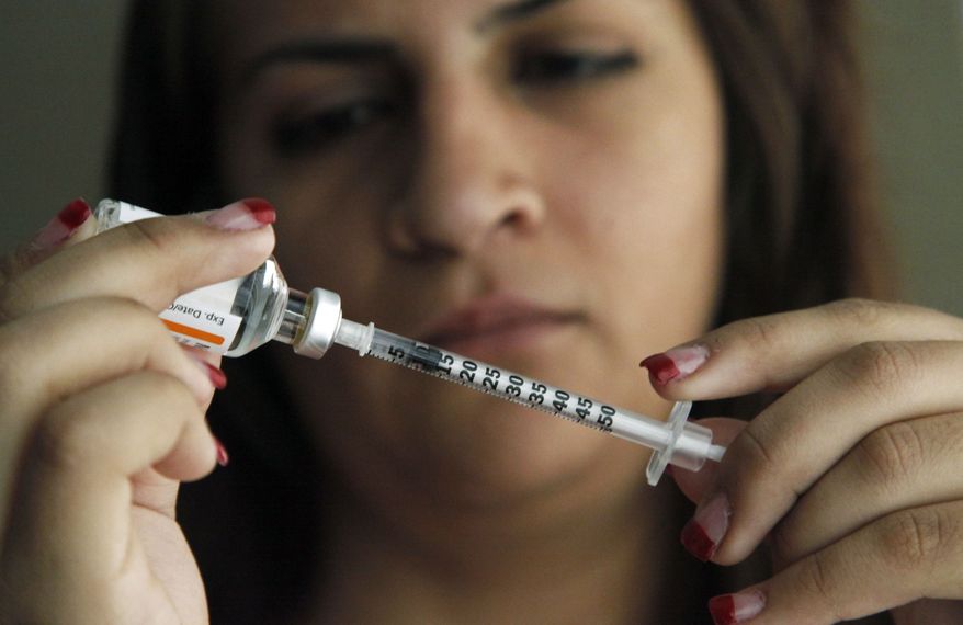 Judith Garcia, 19, fills a syringe as she prepares to give herself an injection of insulin at her home in the Los Angeles suburb of Commerce, Calif., on Sunday, April 29, 2012. (AP Photo/Reed Saxon)