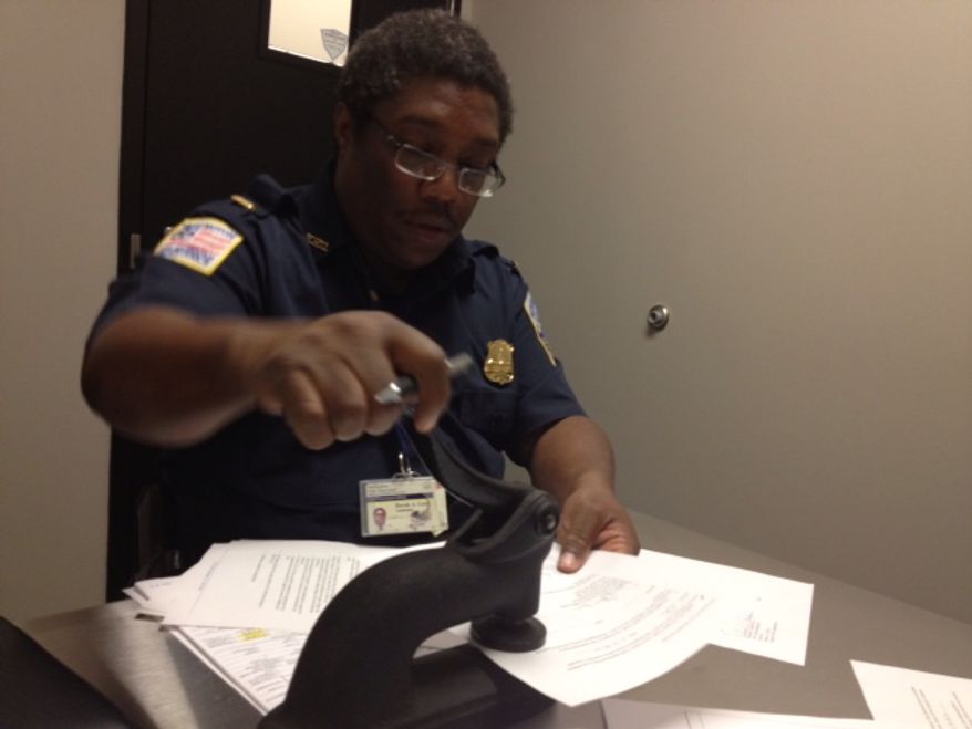 Washington Metropolitan Police Department property clerk approves release of Lt. Augustine Kim's firearms. Photo by Emily Miller for The Washington Times.